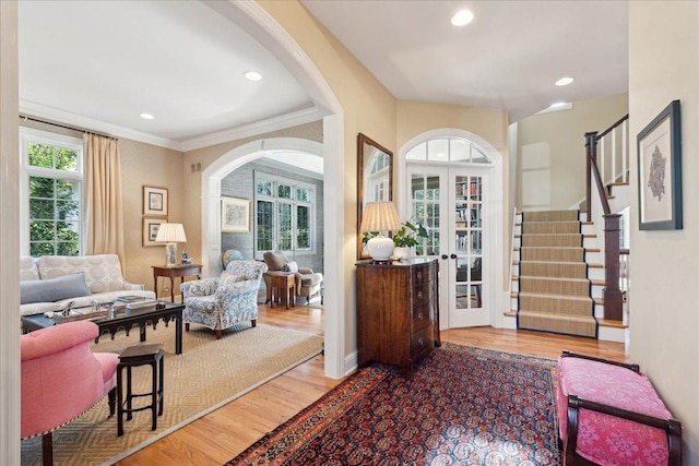 foyer entrance featuring hardwood / wood-style floors, ornamental molding, and french doors