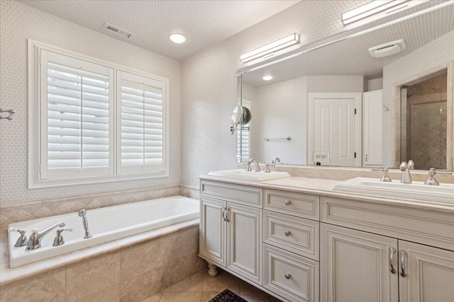 bathroom with tile patterned flooring, vanity, and plus walk in shower