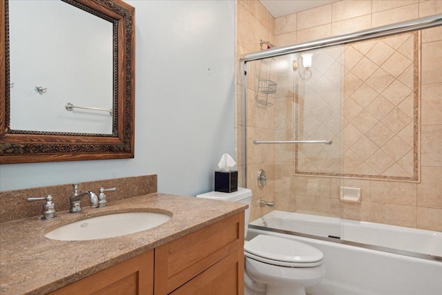 full bathroom featuring vanity, combined bath / shower with glass door, and toilet