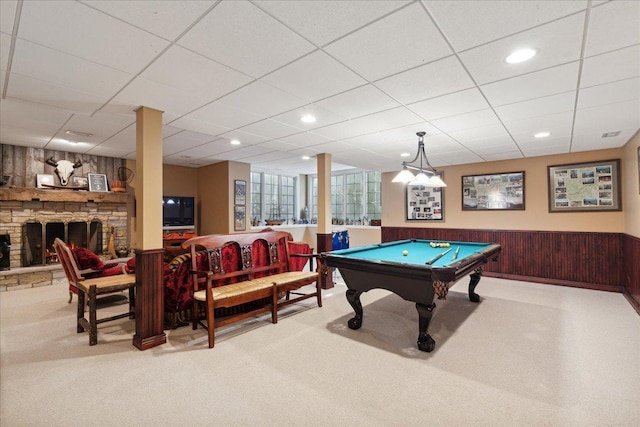 recreation room featuring a paneled ceiling, wooden walls, billiards, and a fireplace