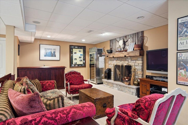 living room with a fireplace, carpet, and a paneled ceiling