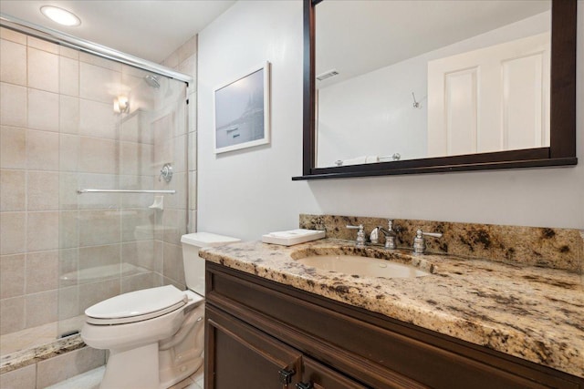 bathroom with vanity, toilet, and an enclosed shower