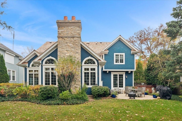 rear view of property featuring a patio and a lawn