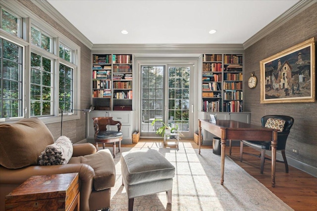 living area featuring hardwood / wood-style flooring, plenty of natural light, and ornamental molding