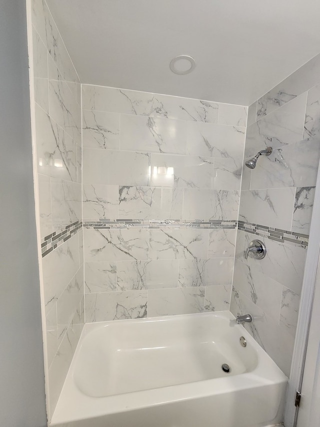 bathroom featuring tiled shower / bath