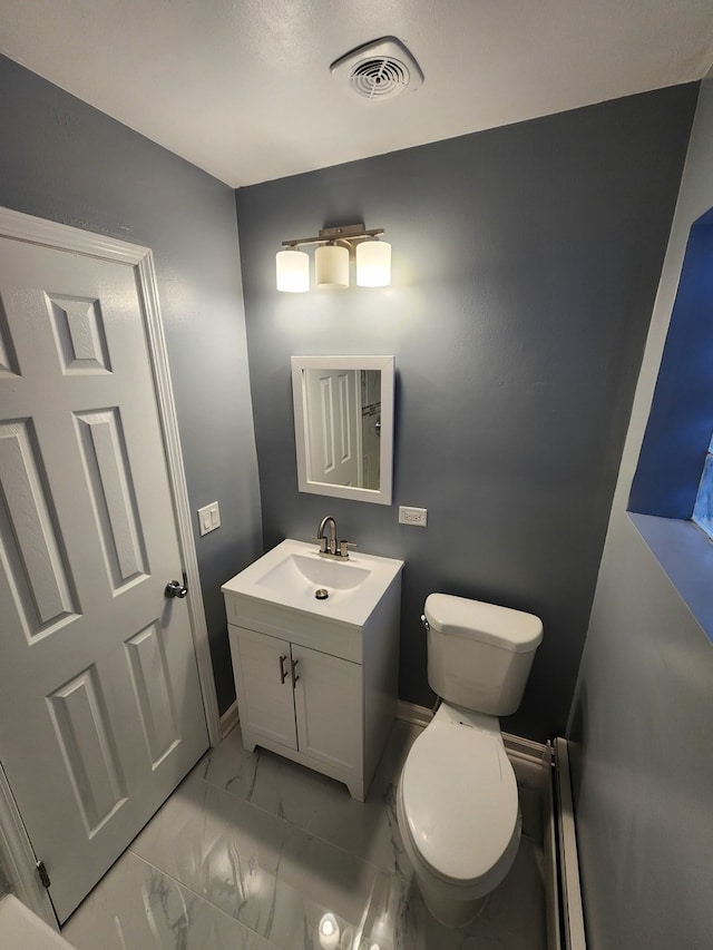 bathroom featuring baseboard heating, vanity, and toilet