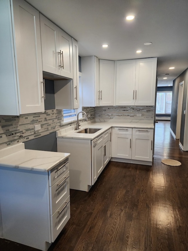 kitchen featuring backsplash, white cabinetry, dark hardwood / wood-style floors, and sink