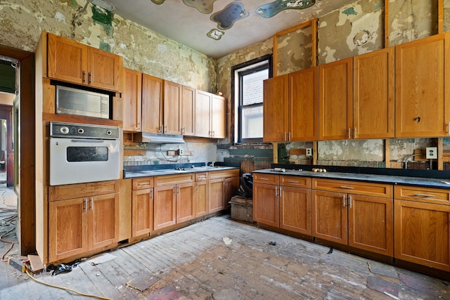 kitchen featuring stainless steel microwave and white oven