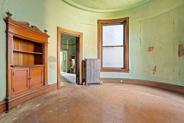 unfurnished room with built in shelves and radiator