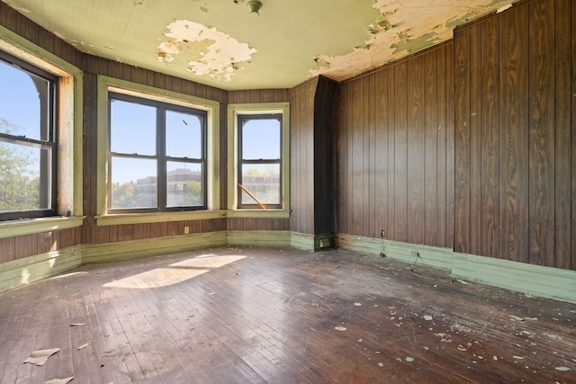 unfurnished room with wood-type flooring and wood walls