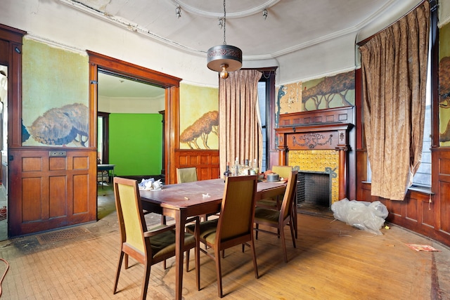 dining area featuring track lighting, crown molding, wooden walls, and light hardwood / wood-style floors