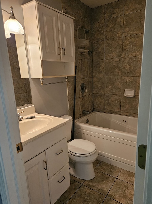 full bathroom featuring vanity, tiled shower / bath, tile patterned floors, and toilet