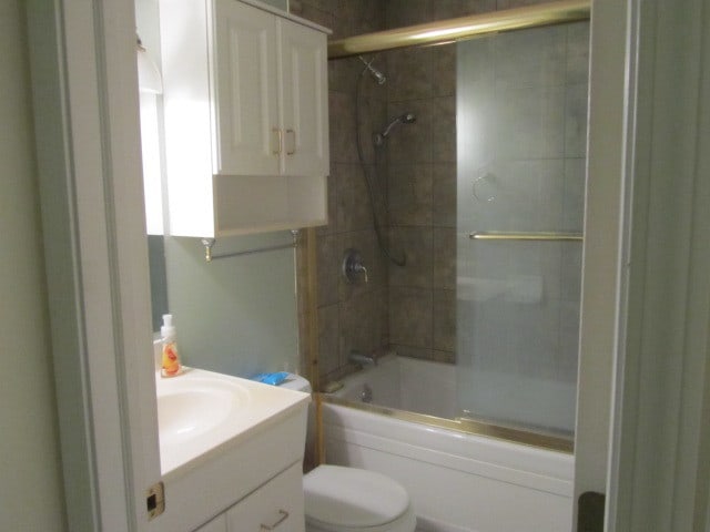 full bathroom featuring vanity, toilet, and combined bath / shower with glass door