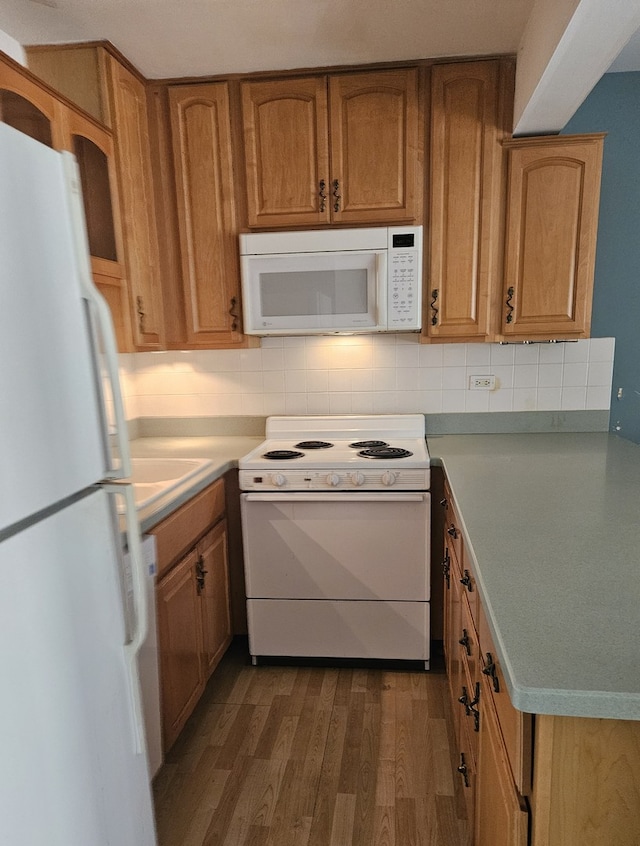 kitchen featuring tasteful backsplash, white appliances, and dark hardwood / wood-style floors