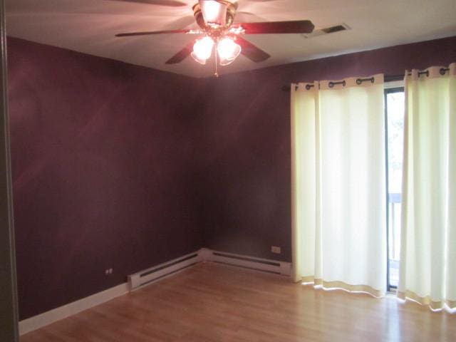 11 Saint Thomas Colony Unit 4, Fox Lake, IL 60020 - spare room featuring ceiling fan, wood finished floors, baseboards, and baseboard heating