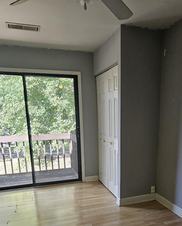 11 Saint Thomas Colony Unit 4, Fox Lake, IL 60020 - unfurnished bedroom featuring access to outside, light wood-style floors, and baseboards