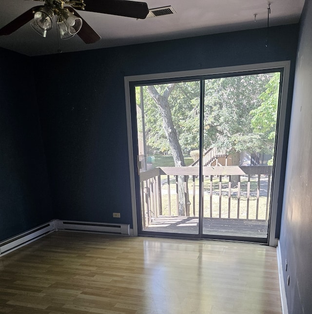 spare room with wood-type flooring, a baseboard heating unit, and ceiling fan