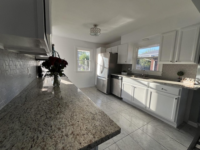 kitchen featuring light stone countertops, white cabinetry, appliances with stainless steel finishes, and sink