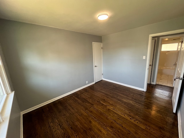 unfurnished room with dark wood-type flooring