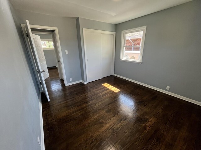 unfurnished room with dark hardwood / wood-style flooring