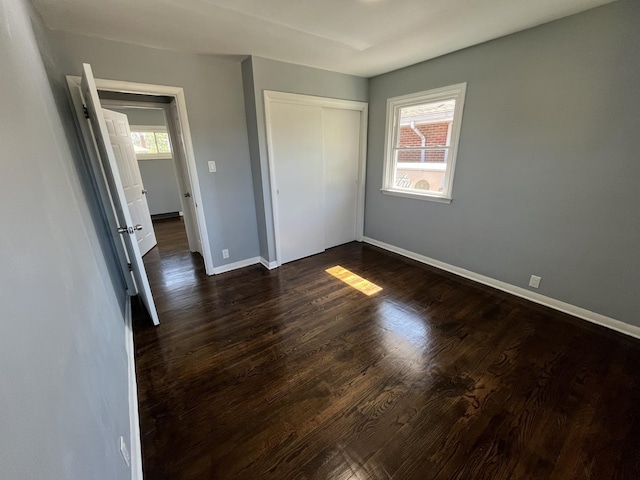 unfurnished bedroom featuring a closet and dark hardwood / wood-style floors