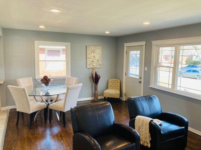 dining area with dark wood-type flooring and a tile fireplace