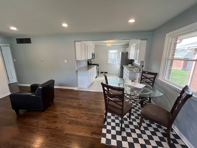 dining area featuring sink and dark wood-type flooring