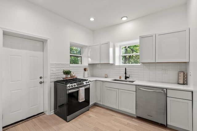 kitchen featuring a wealth of natural light, appliances with stainless steel finishes, light wood-type flooring, and sink