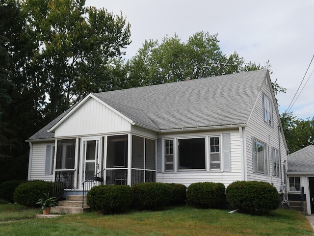 view of front of house with a front lawn and a sunroom