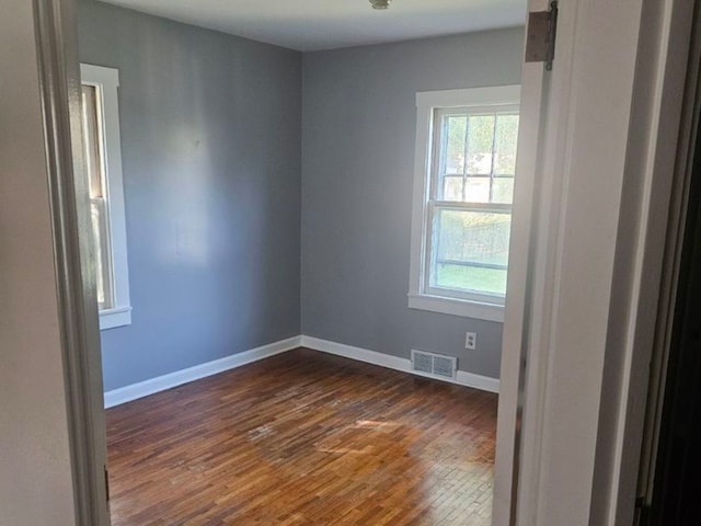 empty room featuring a barn door and dark wood-type flooring