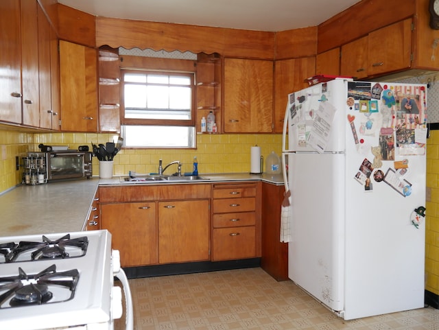 kitchen featuring sink, white appliances, and tasteful backsplash