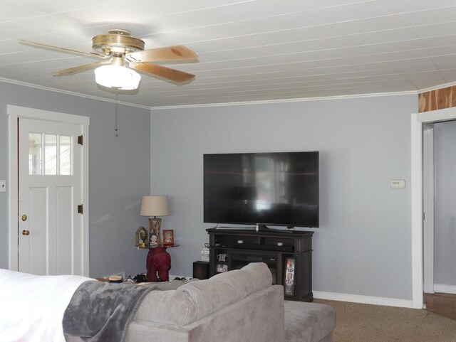 living room with carpet, ceiling fan, ornamental molding, and baseboards