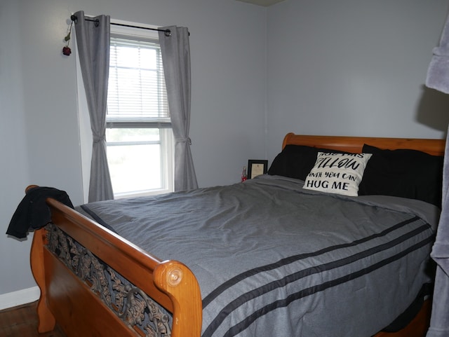 bedroom with dark hardwood / wood-style floors