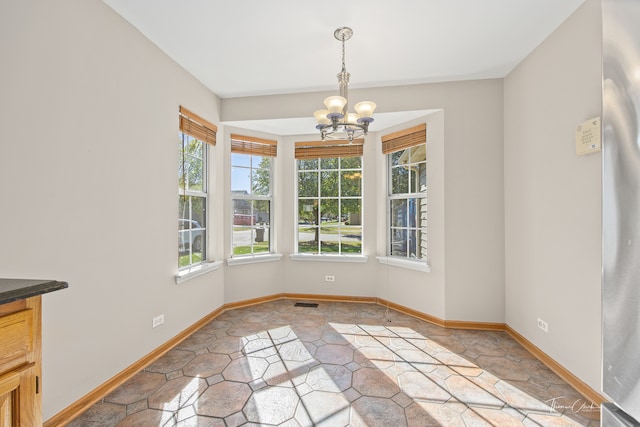 unfurnished dining area featuring a chandelier