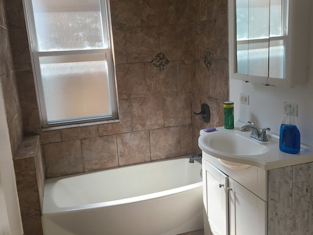 bathroom featuring vanity, plenty of natural light, and a bath