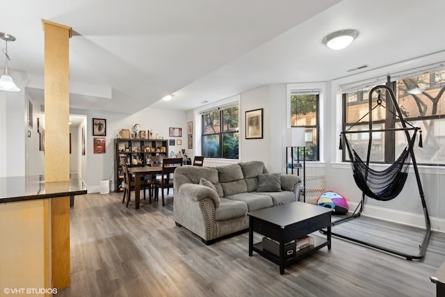 kitchen with a kitchen island, stainless steel fridge, dark stone countertops, dark wood-type flooring, and hanging light fixtures