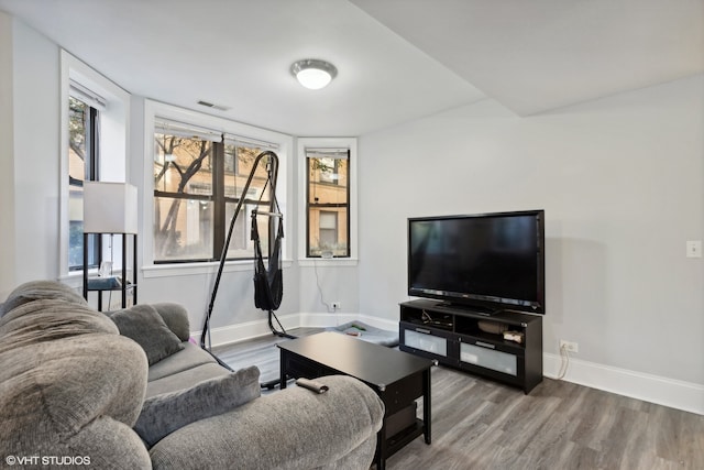 kitchen with light wood-type flooring, pendant lighting, appliances with stainless steel finishes, decorative columns, and a kitchen breakfast bar