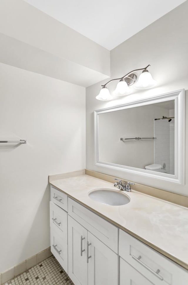 bathroom featuring vanity, tile patterned floors, baseboards, and walk in shower