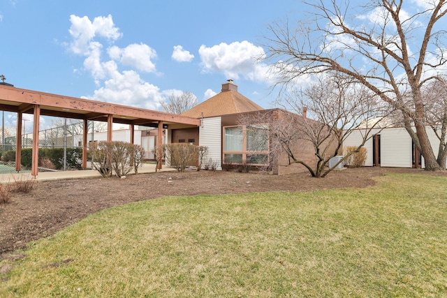 rear view of house with a chimney and a yard