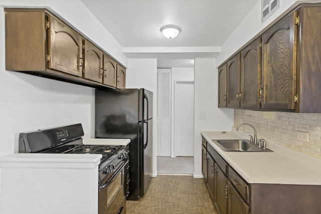 kitchen featuring black gas stove, backsplash, dark brown cabinetry, light countertops, and a sink