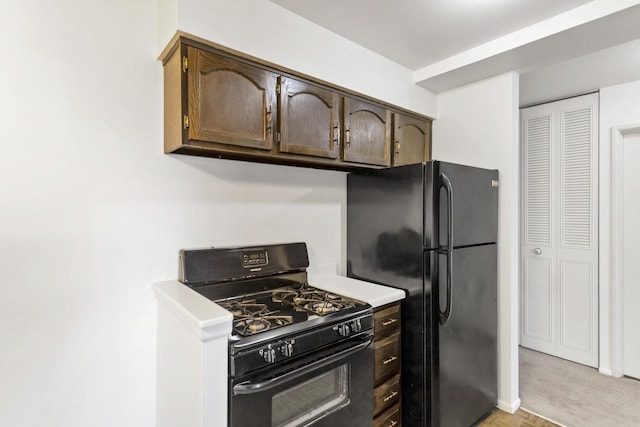 kitchen featuring dark brown cabinetry, black appliances, and light countertops