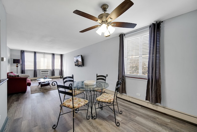 dining area with light wood-type flooring, ceiling fan, baseboard heating, and a healthy amount of sunlight