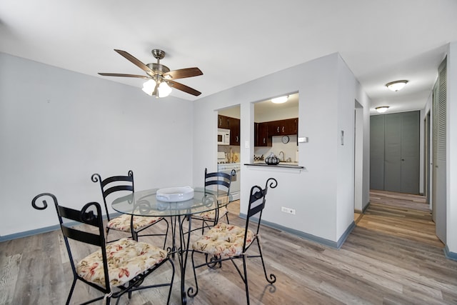 dining area with ceiling fan and light hardwood / wood-style floors