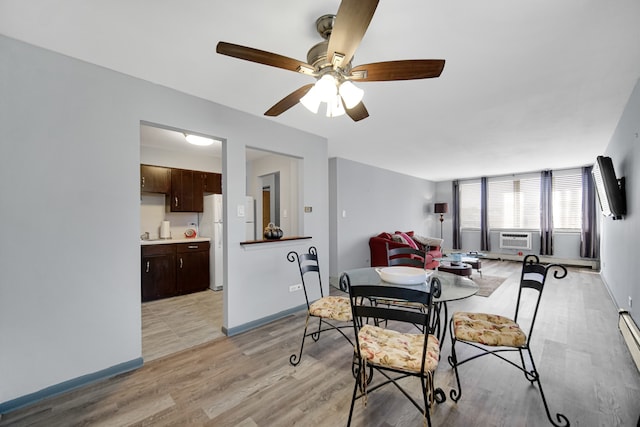 dining room featuring a baseboard radiator, light wood-type flooring, ceiling fan, and cooling unit