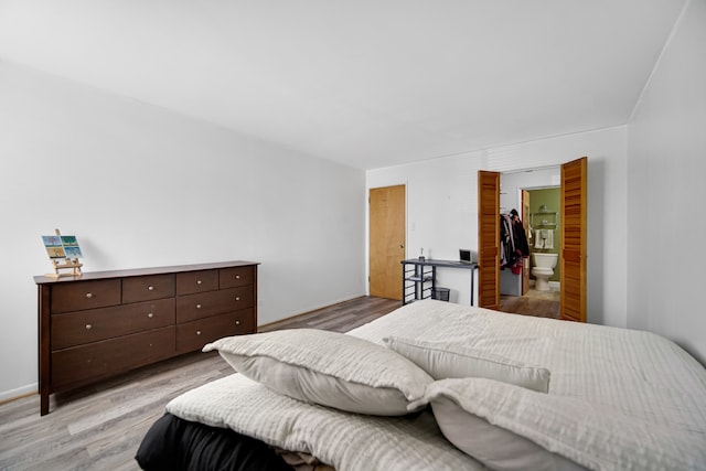 bedroom with a spacious closet, light hardwood / wood-style flooring, and a closet