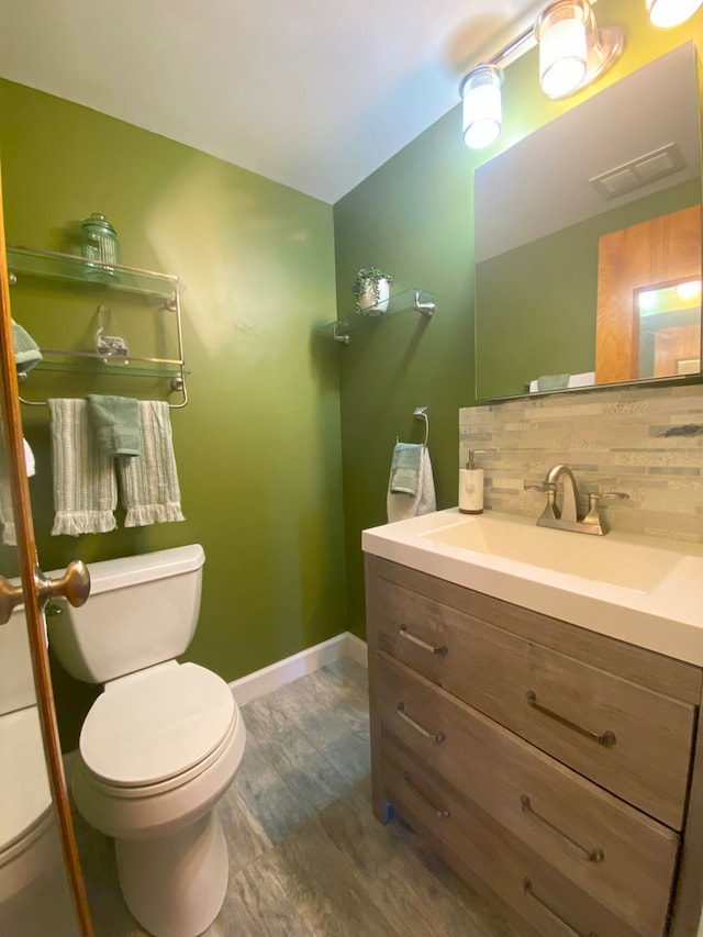 bathroom featuring hardwood / wood-style floors, vanity, backsplash, and toilet