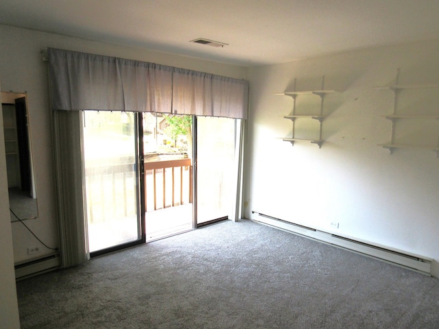 carpeted empty room featuring baseboard heating