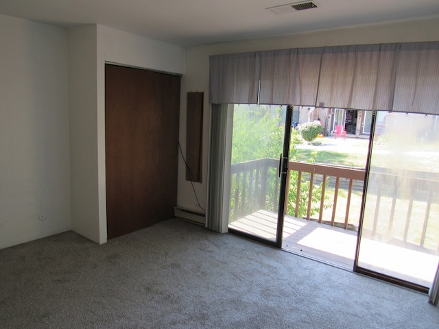 carpeted empty room with baseboard heating