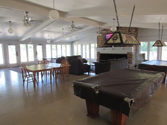 recreation room featuring a brick fireplace, plenty of natural light, and lofted ceiling with beams