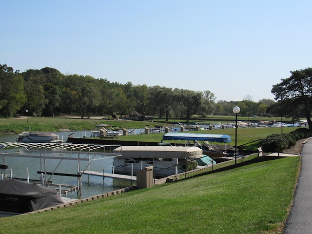 view of dock featuring a lawn and a water view